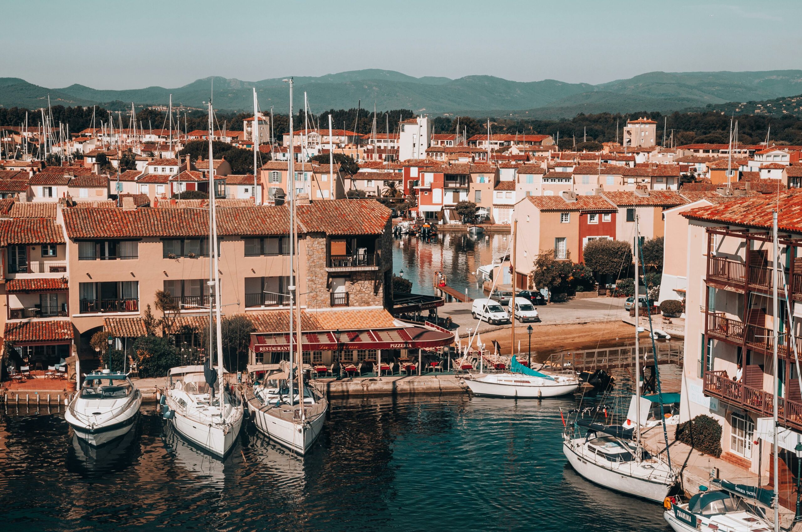 A striking aerial view of Port Grimaud marina with docked sailboats and colorful buildings, capturing the essence of French architecture.